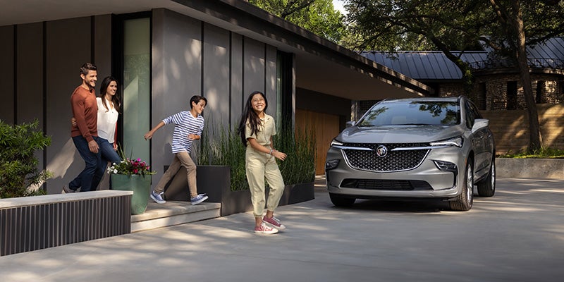famliy coming out of house and Buick Enclave parked outside house
