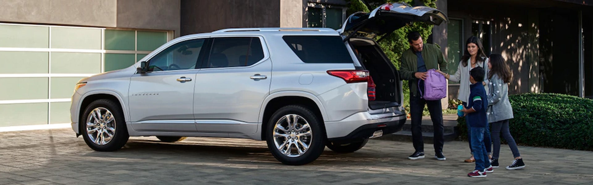family putting bags in trunk of Chevrolet Traverse