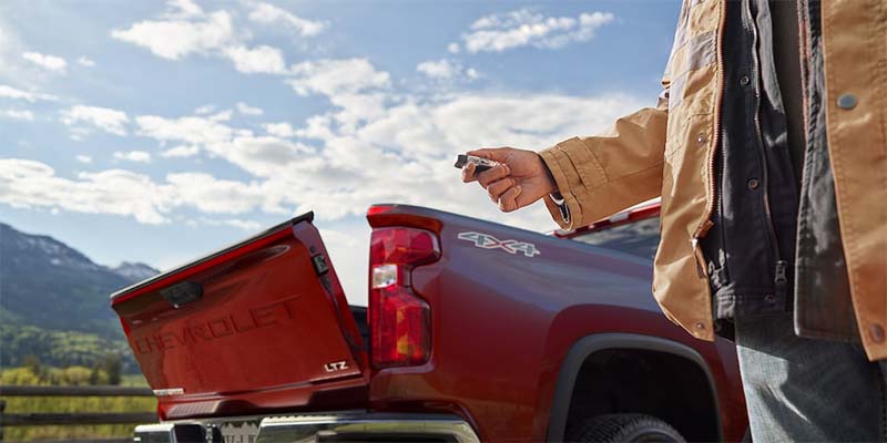 man opening trunk of Chevy Silverado 3500HD with key