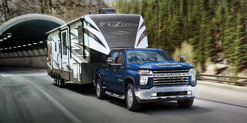 blue Chevy Silverado 3500HD towing a van